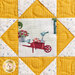 A close up on the yellow patchwork block, showing fabric and top quilting details. 