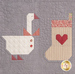 A super close up on a block with a goose and a stocking, demonstrating piecing, top stitching, and embellishment details. 