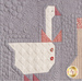 A super close up on a block with a goose, demonstrating piecing, top stitching, and embellishment details. 