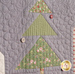 A super close up on a block with a Christmas tree, demonstrating piecing, top stitching, and embellishment details. 