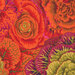 Close up of bright orange fabric covered in olive green, dark red, maroon, and orange florals throughout
