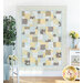 The Easy as ABC and 123 Quilt colored in cream, powder blue, butter yellow, and grey, hung on a white paneled wall and staged with coordinating furniture and matching decor.