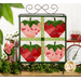 The completed June wall hanging, a pink, red, and green collage of four juicy strawberries, hung on a craft scroll and staged on top a rustic wooden shelf with coordinating decor and flowers.