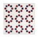The completed Stars Above quilt, a crisp white quilt with circles of red and blue stars, isolated on a white background.