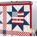 A super close up on the upper right sawtooth star block with an American flag motif, showing fabric and stitching details.
