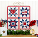 The completed Foundation Paper Piecing Series 2 July wall hanging, hung on a white paneled wall and staged with coordinating patriotic decor.
