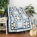 A shot of the quilt, draped over a navy blue chair to demonstrate flow and form.