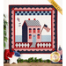The completed Little Garden House in America wall hanging in a patriotic palette of red, white, and blue, hung on a white paneled wall and staged with coordinating decor and leafy plants.