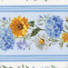 A floral pattern featuring yellow sunflowers, blue hydrangeas, and white daisies on a light blue background.