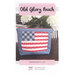Front of the Old Glory Pouch pattern showing the finished project staged on a brown table with flowers in the background.