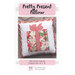 Front cover of the Pretty Present Pillow pattern showing the finished pillow isolated on a stone background.