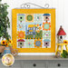 The completed Sunflower Slope wall hanging, hung on a white paneled wall and staged with coordinating flowers and a birdhouse.