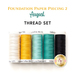 The August thread set, five spools of thread in cream, yellow, aqua, teal, and black, isolated on a white background below a text graphic that reads 