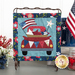 The completed Liberty Heights - Truck Mini Quilt, hung on a craft display and staged with coordinating flowers and decor.