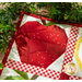 A close up shot of the red apple from above, surrounded by a draped green leafy garland with artful shadows and lighting cast across the project.