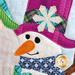 A super close up on the applique snowman, showing fabric and topstitching details.