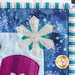 A super close up on an applique snowflake, showing glittery fabric and topstitching details.