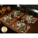 The four completed placemats staged on a wooden table with coordinating Halloween glassware and decor.