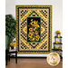 The completed Sunflower Splendor Panel Quilt in bright yellow, black, and grass green fabrics, staged on a white paneled wall with coordinating sunflower themed decor.