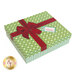 Green gift box that the quilt ships in, decorated with a red ribbon and bow, adorned with a Merry Christmas tag.