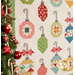 Close up on the various ornament designs on a light background, a decorated tree, peeks into frame from the left side.