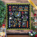 The completed Aviary quilt, hung on a rustic wood panel wall and staged with coordinating foliage, flowers, and decor. A yellow banner in the upper right hand corner reads 