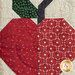 A super close up on one of the apple blocks, demonstrating fabric and top quilting details.