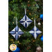 The three completed cathedral ornaments in dark, light, and icy blue, staged on a decorated and lit Christmas tree.