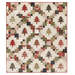 A winter themed cream quilt with evergreen trees and green, red, and brown fabric blocks making a lattice pattern, isolated on a white background.