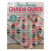 The front of the Time-Saving Charm Quilts book showing one of the completed quilts displayed on a white bed.