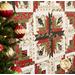 An angled shot of the quilt, focused on the center block, demonstrating piecing details; a decorated Christmas tree peeks into frame from the left side.