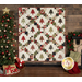 A winter themed cream quilt with evergreen trees and green, red, and brown fabric blocks making a lattice pattern