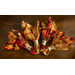 A top down shot of four cloth napkins in four metal napkin rings, fanned out on a dark wood table.