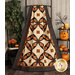 A head-on shot of the quilt, artfully draped over a rustic quilt ladder, staged with coordinating Halloween decor.