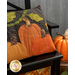 A close up on the right side of the pillow, demonstrating fabric and top quilting details, staged with coordinating fall decor. 