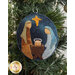 A super close up on the Jesus, Joseph, and Mary wool ornament, demonstrating fabric, applique, and stitching details.