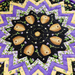 A colorful quilt center featuring a star pattern with beehives and floral designs in purple and black.