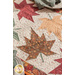 A close up on the maple leaf runner, demonstrating details on the brown leaf print pattern and top quilting details.