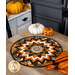 The completed topper in black, white, and orange Halloween fabrics, staged on a wooden table with coordinating decor.