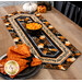 A table setting featuring the completed table runner with pumpkins and staged with coordinating decor and candy corn.