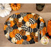 A top shot of the decorative pumpkins oval placemat set with silverware, surrounded by coordinating Halloween decor.