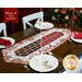 The 2 completed Easy Striped Table Runners, colored in cream, brown, and red fabrics from the Baking Up Joy collection, displayed on a wooden table and staged with coordinating tableware. A decorated Christmas tree can be seen in the background, and a ribbon in the top left corner reads 