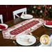 The completed Easy Striped Table Runner, colored in cream and red fabrics from the Baking Up Joy collection, displayed on a wooden table and staged with coordinating tableware. A decorated Christmas tree can be seen in the background.