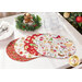 The four completed Oval Placemats colored in red and white fabrics from the Sugar Coated collection, slightly fanned out and staged on a white table, surrounded by coordinating tableware and Christmas decor.