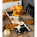 The completed Scaredy Cat Table Runner, staged on a rustic wood table with coordinating table settings, and decor; a tin with an autumn bouquet sits at the center.