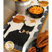 A close up on one end of the runner, demonstrating fabric color and print details. A bowl of candy corn sits in the center beside a tin with yellow flowers.