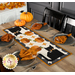 A fall dining table set for four, featuring the quilted runner with pumpkins and black cats in the center.