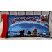 A decorative pillow featuring dogs watching Santa's sleigh and reindeer against a snowy backdrop.