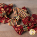 A close up of the four napkins slightly fanned out on a wood table top, held by brushed gold napkin rings.