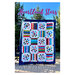 The front of the Heartland Stars pattern featuring the finished quilt being held up in front of pine trees in a backyard.